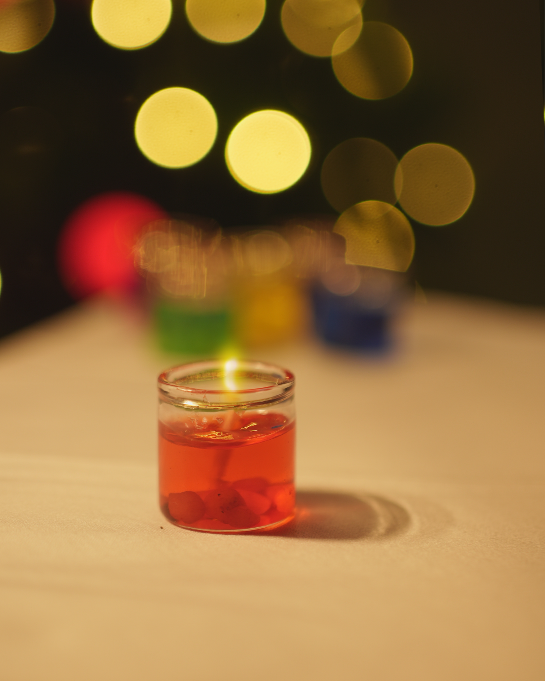 Colorful votive candles or wax melts, with a festive bokeh background and wax gel in red colour.